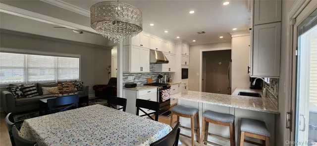 a kitchen with a dining table chairs and white cabinets