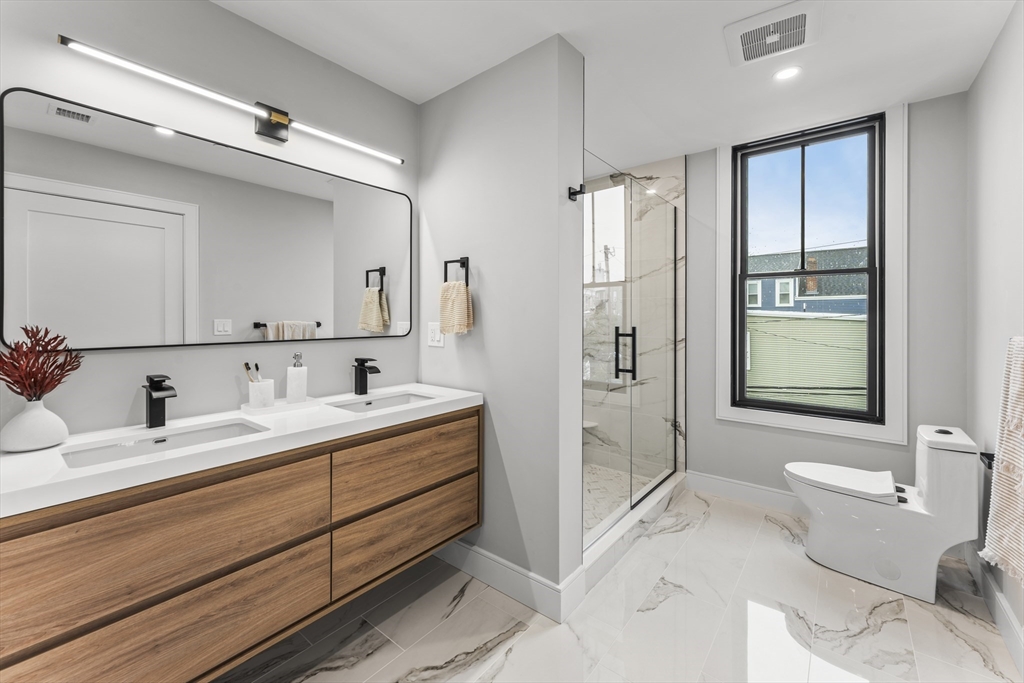 106 Moore Street, Unit 8 Boston, MA 02128 - Photo 5 of 9 a bathroom with a granite countertop sink toilet and shower