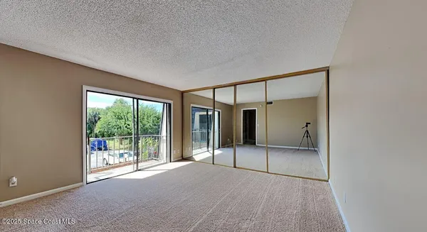 an empty room with sliding glass door and mountain view