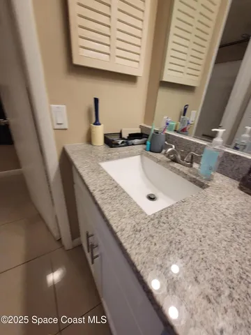 a bathroom with a granite countertop sink and a mirror