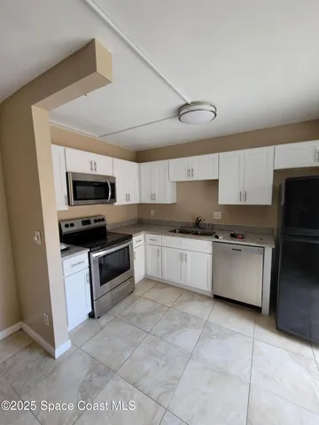 a large kitchen with a stove top oven and cabinets