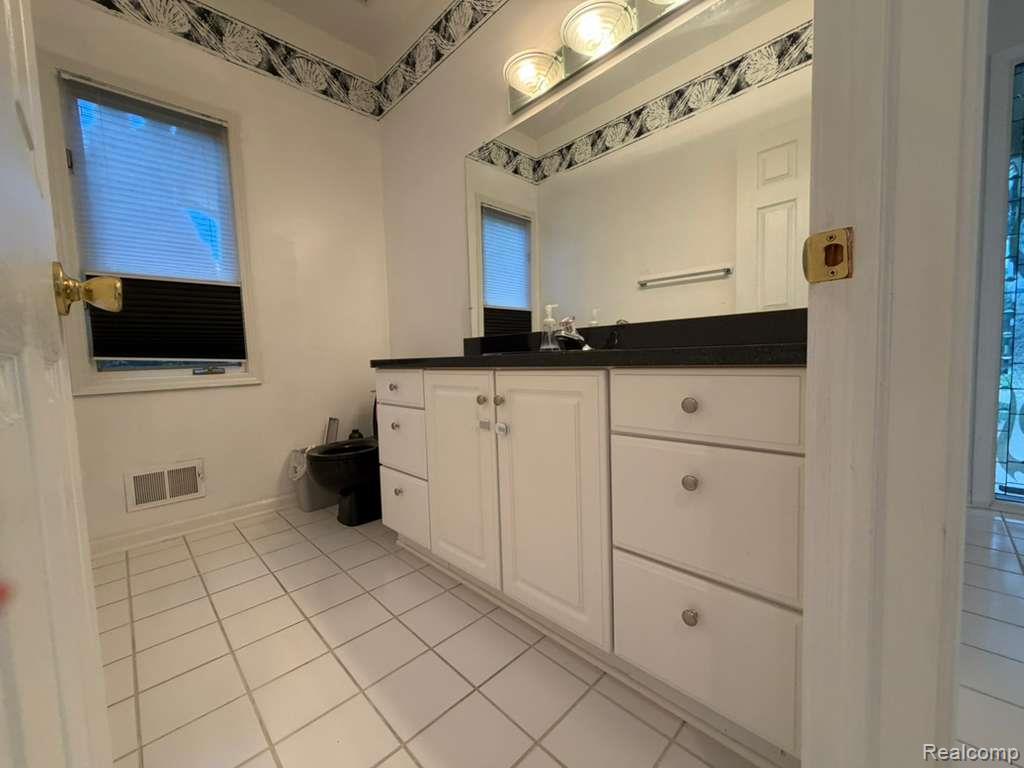 1154 Bluebird Drive Rochester, MI 48307 - Photo 18 of 34 Bathroom vanity with white cabinetry, dark countertop, and integrated sink