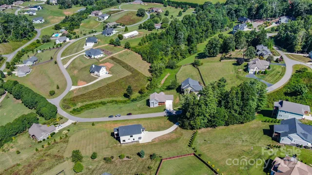 an aerial view of a house with a yard and lake view