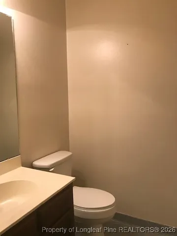 an empty room with wooden floor cabinet and windows