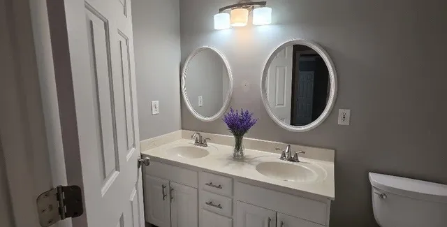 a bathroom with a sink a toilet and a mirror