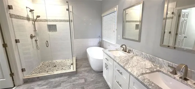 a spacious bathroom with a granite countertop tub sink and mirror