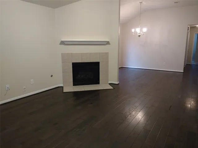 a view of a livingroom with wooden floor a fireplace and a window