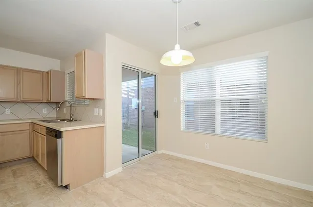 a kitchen with a stove a sink and chandelier
