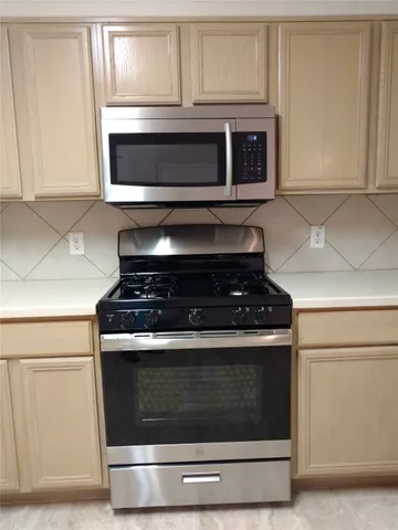 a stove top oven sitting inside of a kitchen