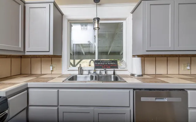 a kitchen with granite countertop a sink and cabinets
