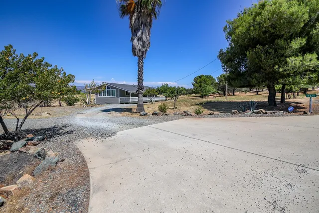 a view of a road with a bench and trees