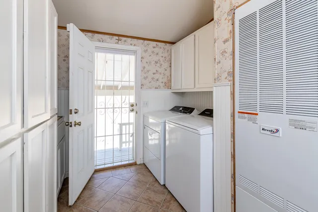 a view of a kitchen with white cabinets and a refrigerator