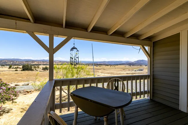 a view of a balcony dining table and chairs with wooden floor