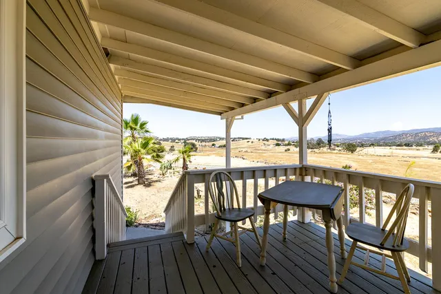 a view of a balcony with furniture and wooden floor