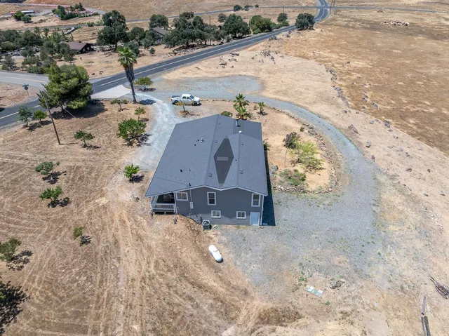 an aerial view of a house with a yard and trees