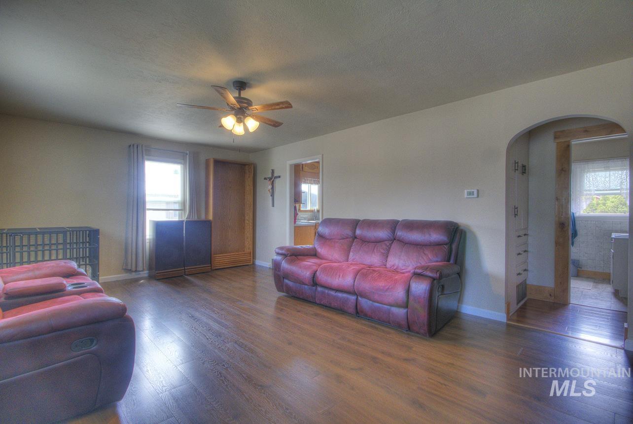 351 West Main Street South Vale, OR 97918 - Photo 4 of 33 Spacious room featuring wood-finish flooring, a ceiling fan with integrated lighting, and neutral wall tones
