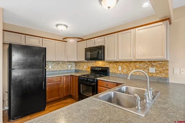 a kitchen with granite countertop a refrigerator sink and stove