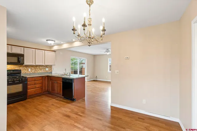 a large kitchen with stainless steel appliances granite countertop a stove and cabinets with wooden floor