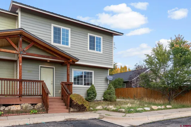 a front view of a house with a yard and balcony