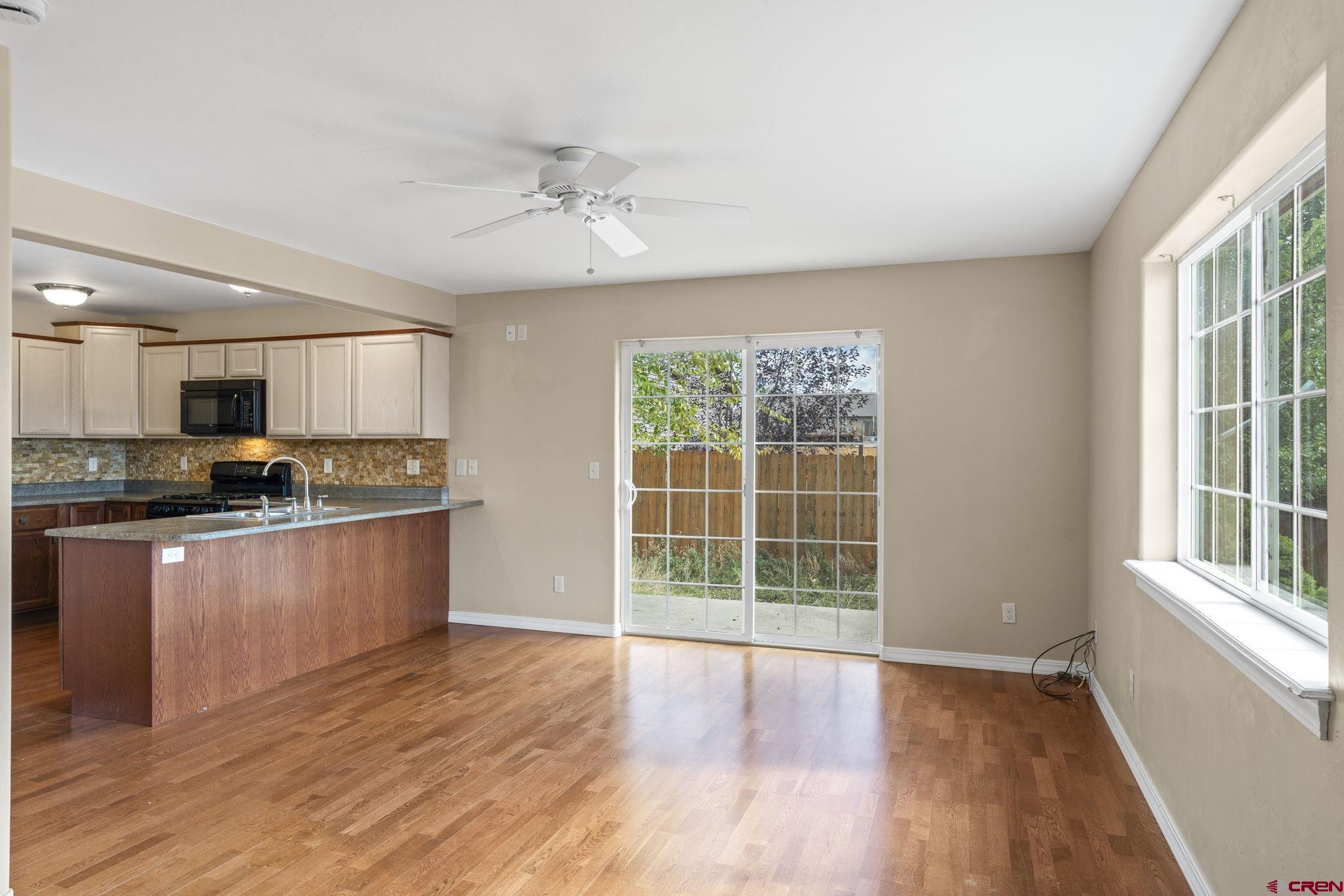 724 Jacobs Lane Bayfield, CO 81122 - Photo 4 of 33 a large kitchen with stainless steel appliances granite countertop a stove a refrigerator a sink a microwave oven with cabinets and wooden floor