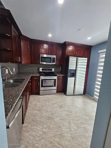 a kitchen with stainless steel appliances granite countertop a refrigerator stove and sink