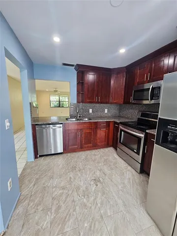 a kitchen with stainless steel appliances granite countertop a stove a sink and a microwave