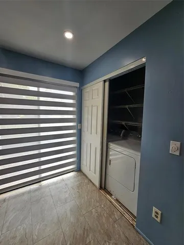 a view of empty room with a window and a ceiling fan