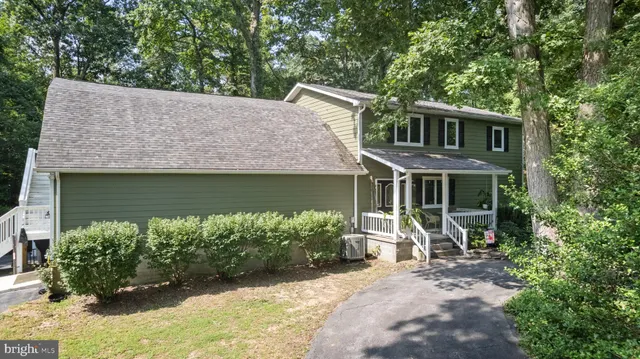 an aerial view of residential houses with outdoor space and trees