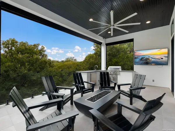 a view of a patio with a dining table and chairs with a floor to ceiling window