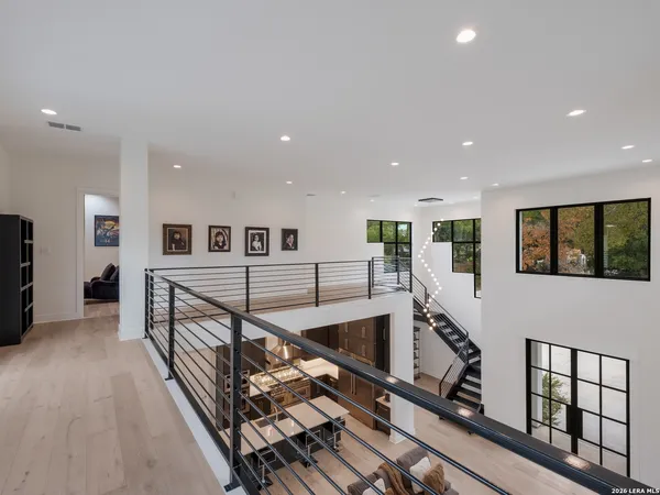 a view of a hallway with wooden floor and stairs