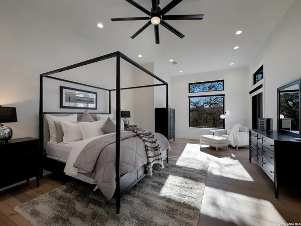 a bedroom with a large bed and a chandelier