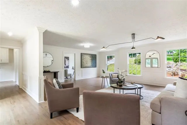 a kitchen with stainless steel appliances granite countertop a stove a sink a center island and a wooden floor