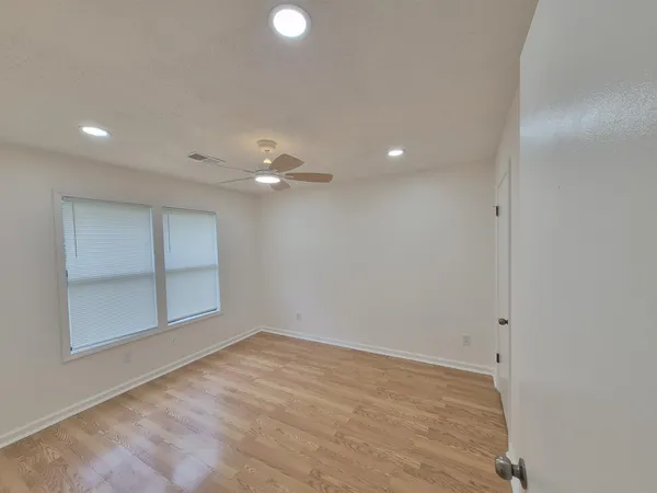 en empty room with window and ceiling fan