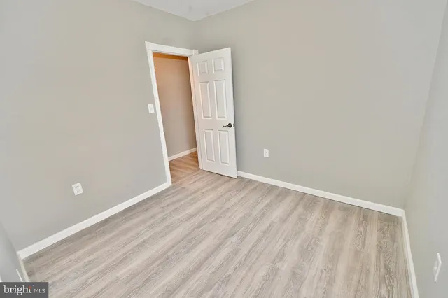 an empty room with wooden floor and closet