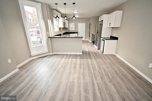 a view of a kitchen with wooden floor and electronic appliances