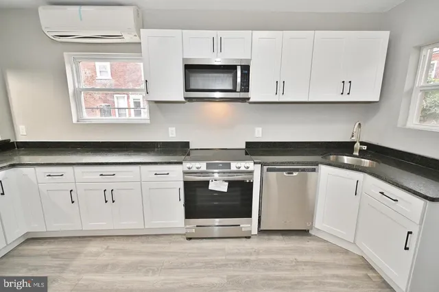 a kitchen with stainless steel appliances granite countertop a sink a stove and a microwave