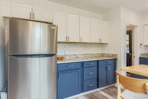 a kitchen with a refrigerator a stove and cabinets