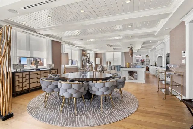 a dining room with furniture a rug and kitchen view