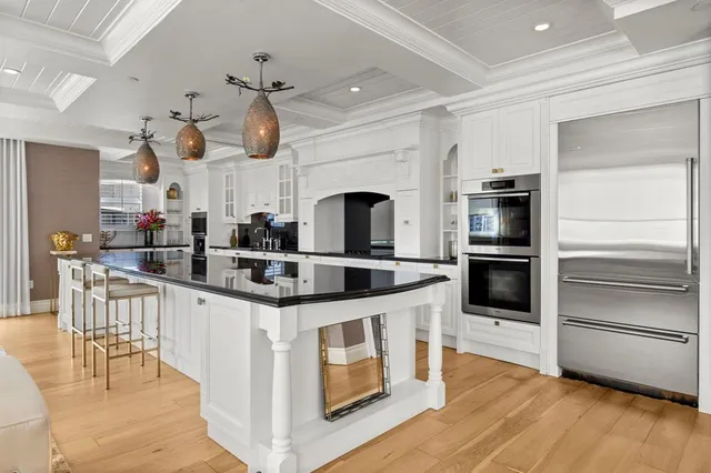 a kitchen with kitchen island granite countertop a sink and cabinets