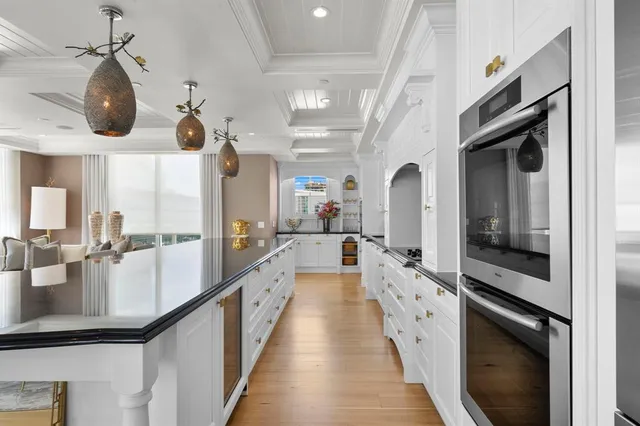 a kitchen with granite countertop a white cabinets and window