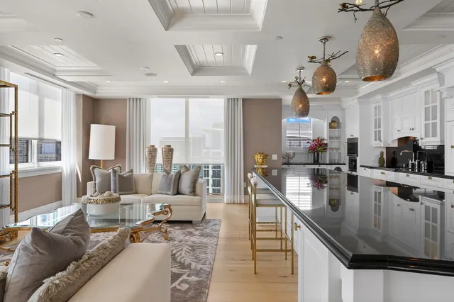 a living room with stainless steel appliances furniture and a view of kitchen