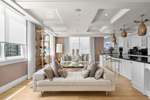 a living room with furniture kitchen view and a wooden floor