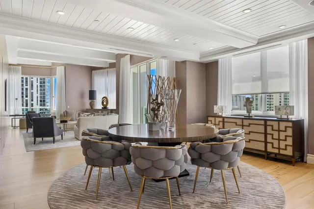 a kitchen with stainless steel appliances kitchen island granite countertop a table chairs and a refrigerator