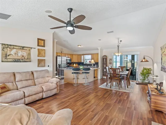 a living room with furniture kitchen view and a chandelier