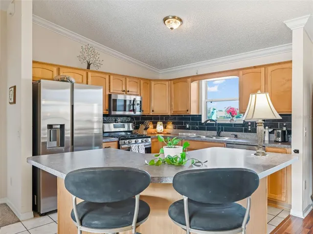 a kitchen with counter top windows and chairs