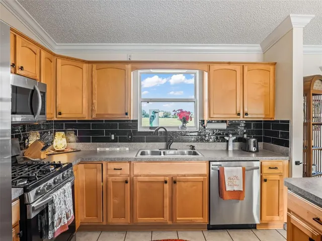 a kitchen with stainless steel appliances granite countertop a stove a sink and a microwave