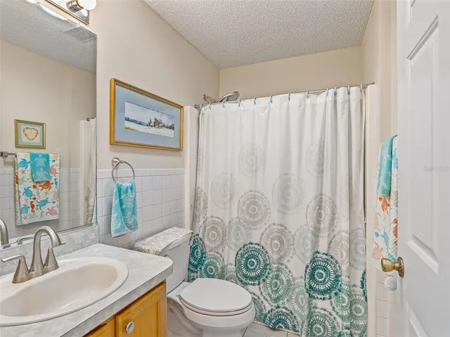 a bathroom with a sink a toilet and shower curtain