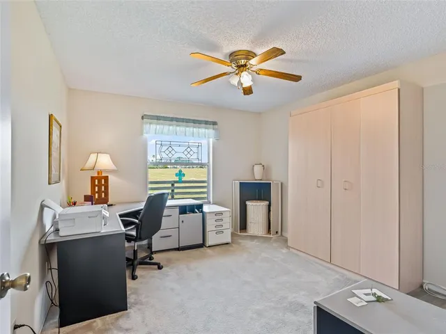 a view of a workspace with furniture and a window