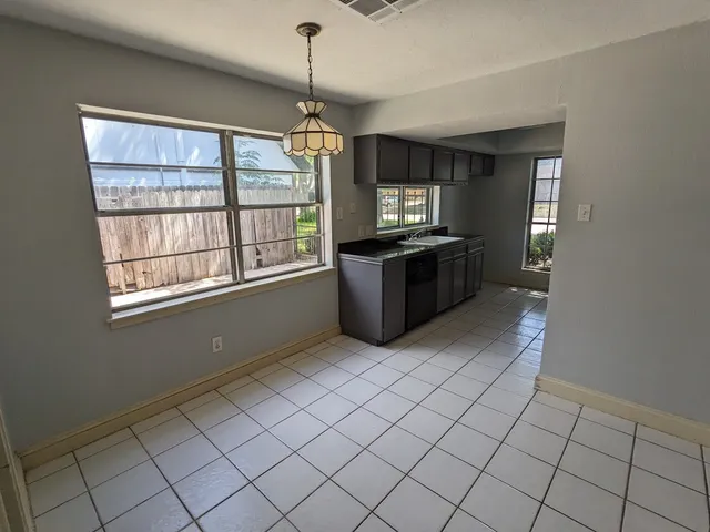 a kitchen with stainless steel appliances granite countertop a stove a sink and a window