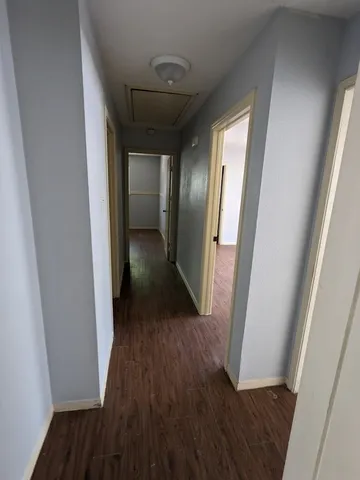 a view of a hallway with wooden floor